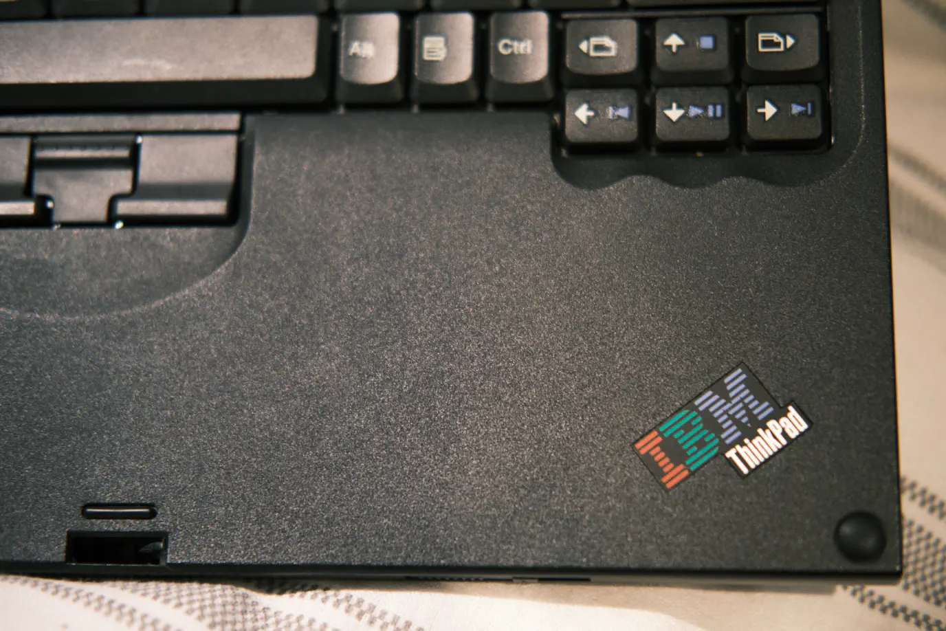 The wrist rest of a ThinkPad X60T showing the trackpoint buttons and arrow keys.